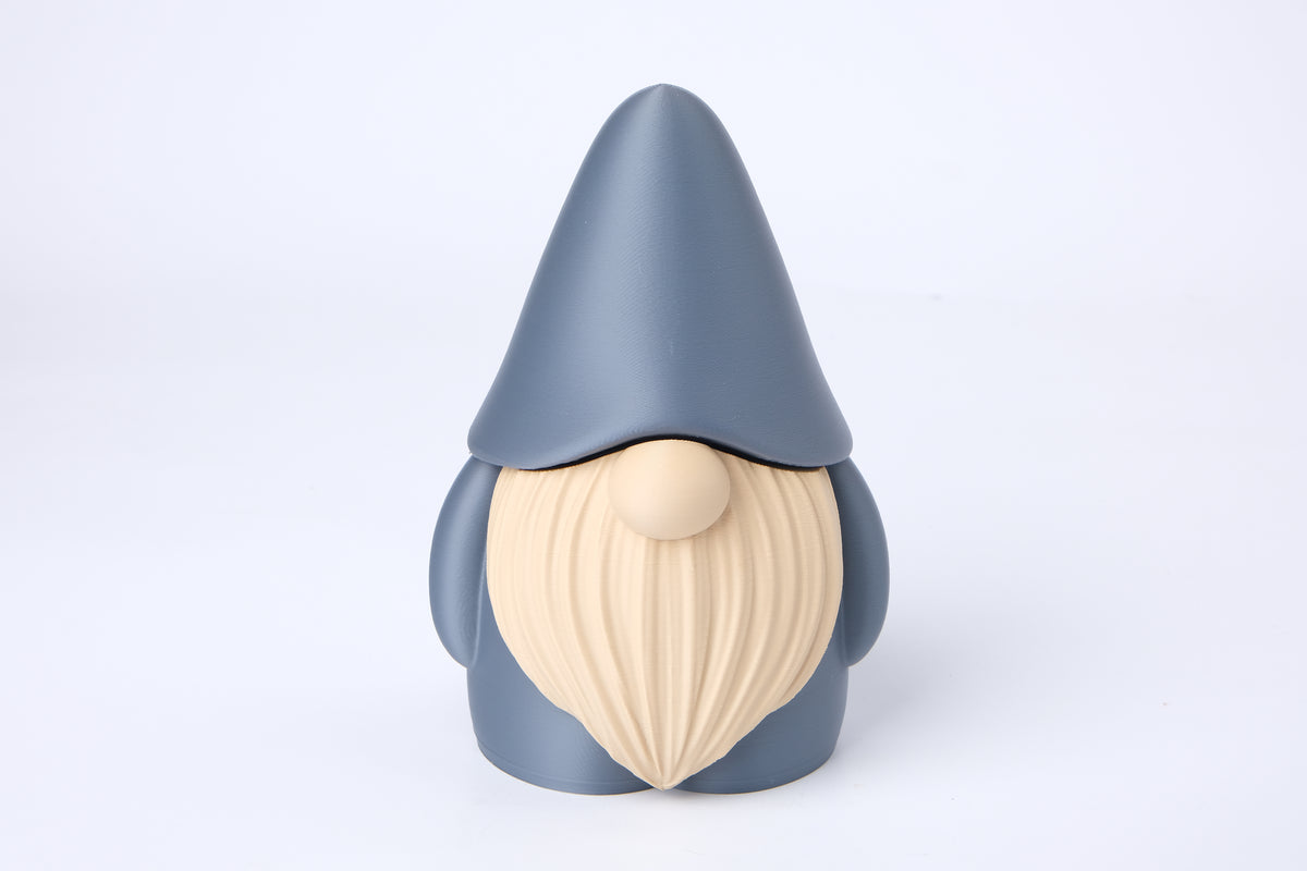 Figurine de lutin sur une bibliothèque près de bougies et d'une petite plante dans un intérieur cosy