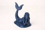 Figurine de sirène éthérée sur une étagère en bois près d'une déco marine