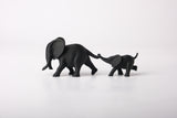 Sculpture de couple d'éléphants sur une étagère en bois près d'une petite plante et d'un vase en céramique