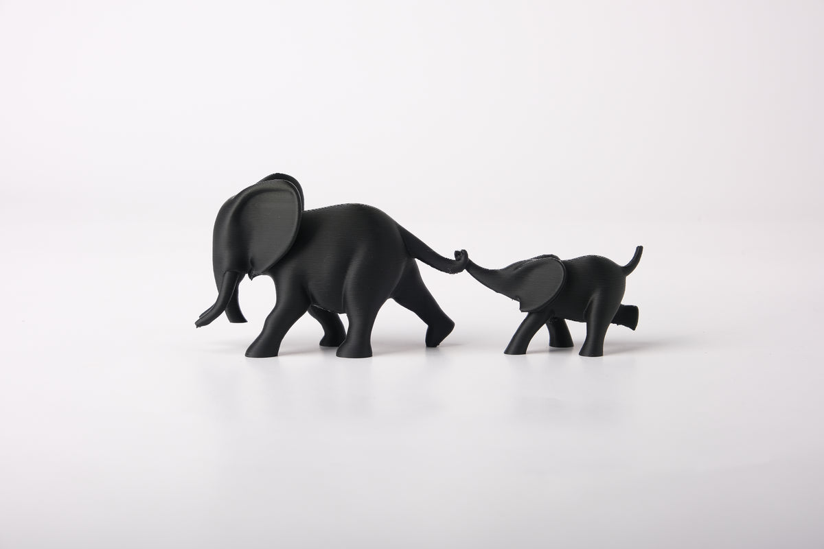 Sculpture de couple d'éléphants sur une étagère en bois près d'une petite plante et d'un vase en céramique
