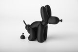 Sculpture de chien ballon sur une étagère en bois près de livres et de petits objets