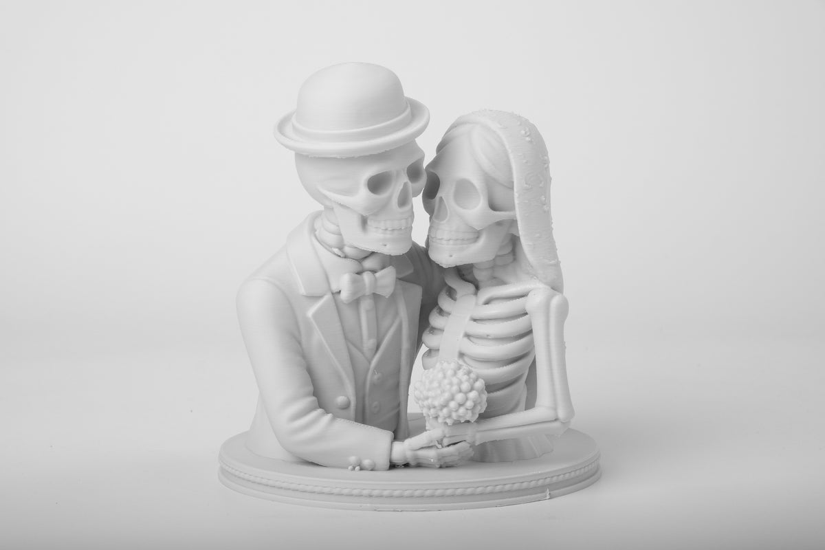 Figurine gothique de mariés squelettes sur une étagère en bois foncé avec bougies et déco ténébreuse