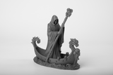 Death Arrived – statue gothique sur une étagère en bois foncé à la lueur des bougies