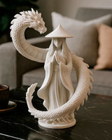 Gros plan du gardien au dragon – figurine en cape avec dragon enroulé, blanc mat