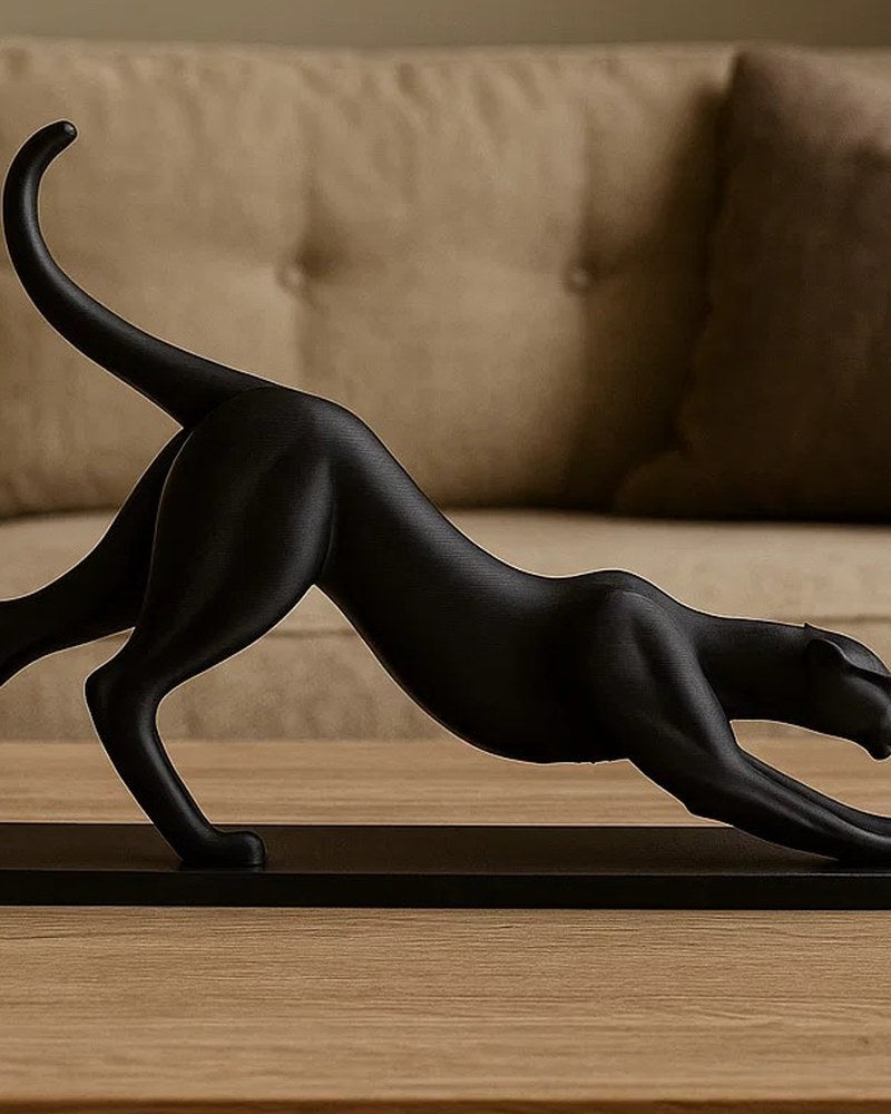Gros plan d'une sculpture de panthère noire qui s'étire sur une surface blanche