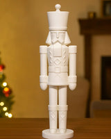 Sculpture de casse-noisette minimaliste blanc mat sur une étagère blanche, vue de face