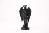 Figurine d'ange sur une étagère en bois foncé avec bougies et plantes séchées