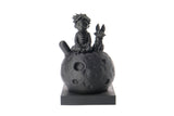Sculpture du Petit Prince et du renard sur une bibliothèque en bois à côté de livres