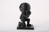 Statue d'astronaute Atlas moderne sur un bureau minimaliste avec des livres et une déco neutre