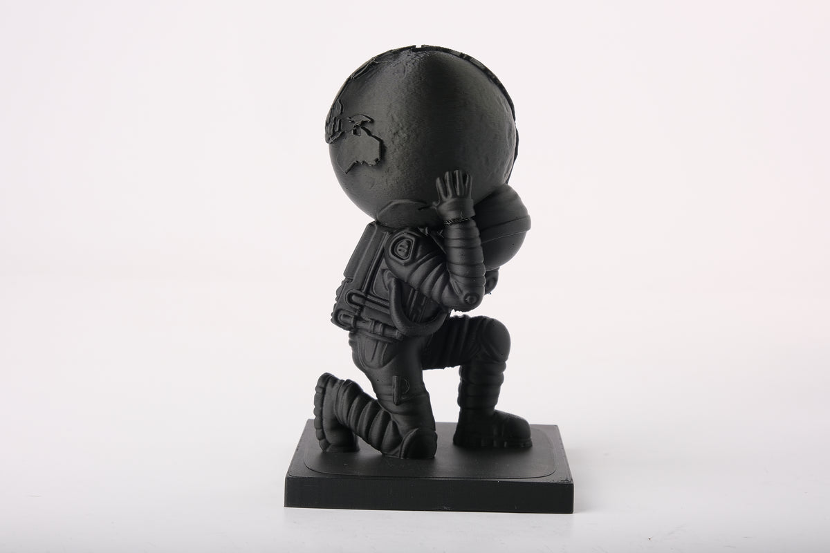 Statue d'astronaute Atlas moderne sur un bureau minimaliste avec des livres et une déco neutre