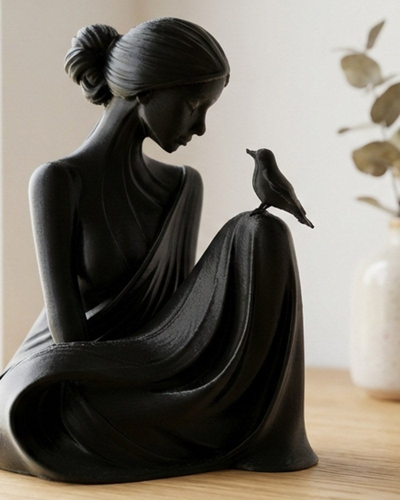 Sculpture blanche minimaliste d'une femme et d'un oiseau, vue de face sur une surface claire
