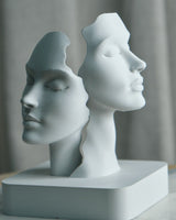 Gros plan d'une sculpture de deux visages abstraits réunis en une forme minimaliste