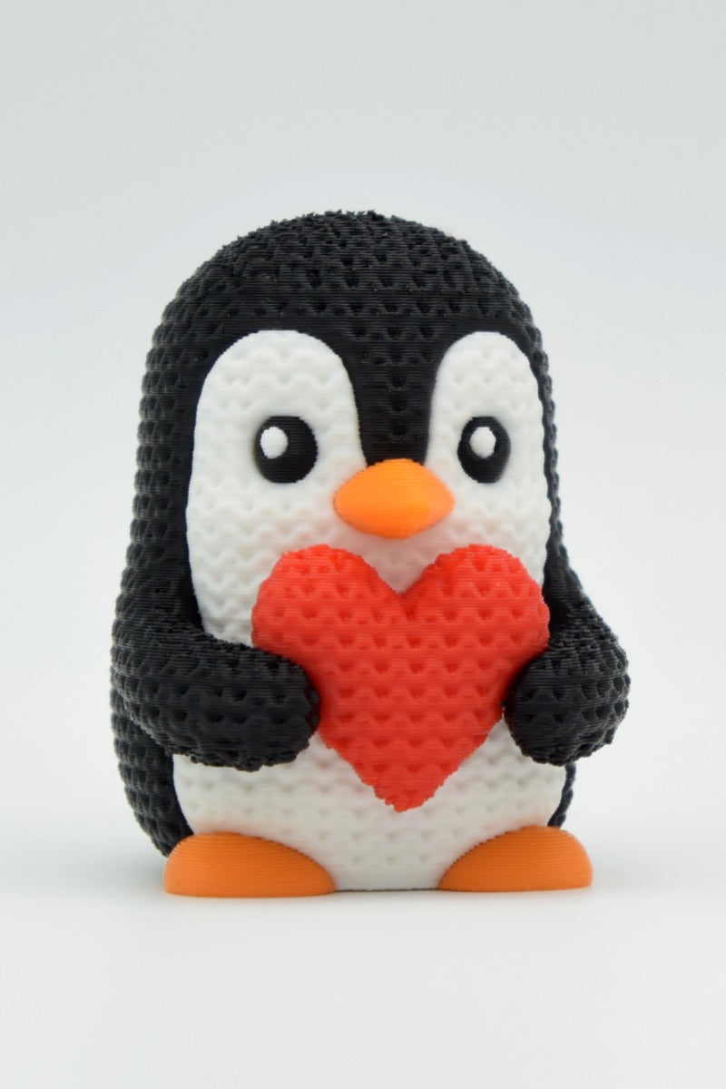 Gros plan d'un pingouin de la Saint-Valentin tricoté et texturé avec petit cœur