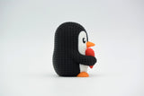 Pingouin tricoté de la Saint-Valentin sur une étagère en bois à côté d'une bougie et de fleurs séchées