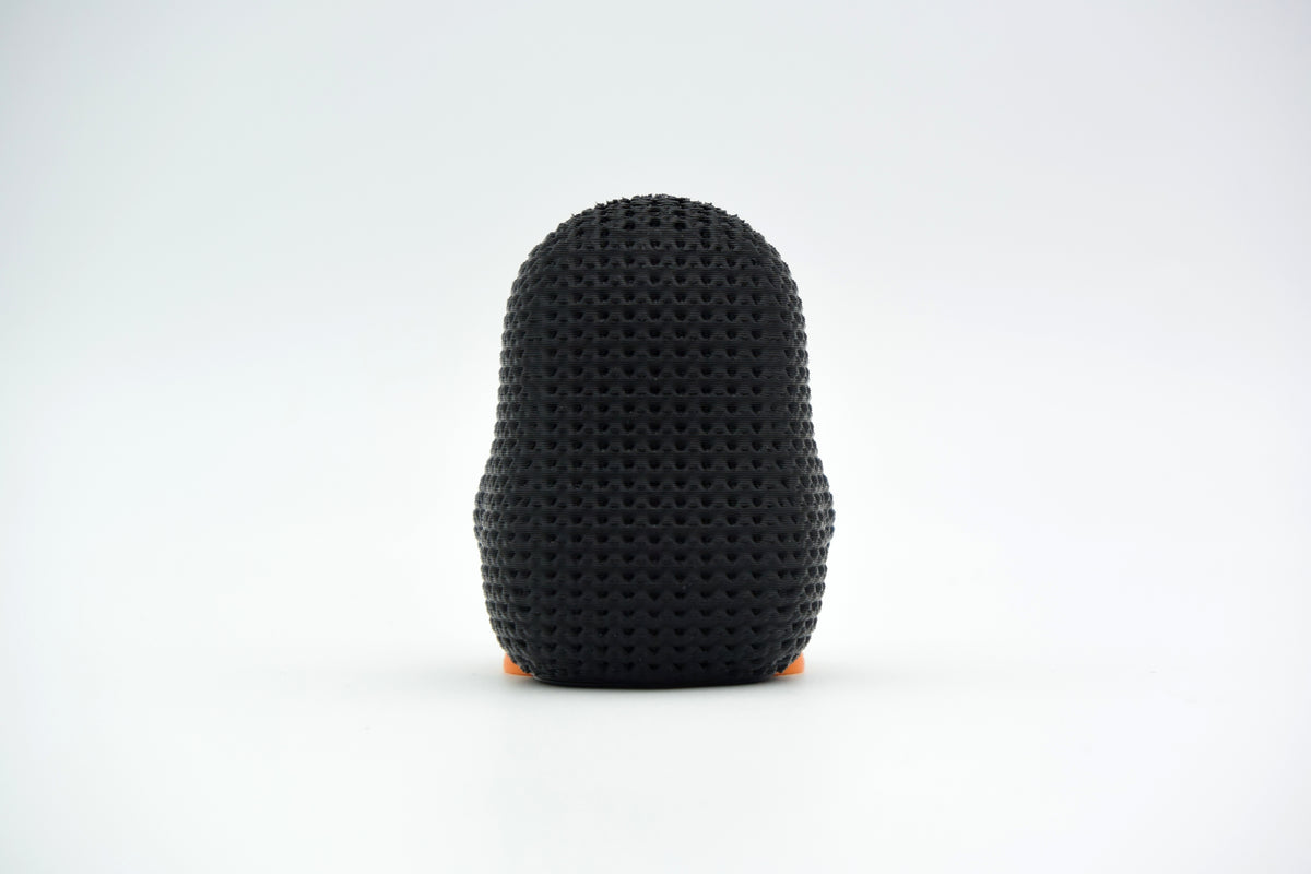 Gros plan de la texture tricotée d'une petite figurine décorative de pingouin