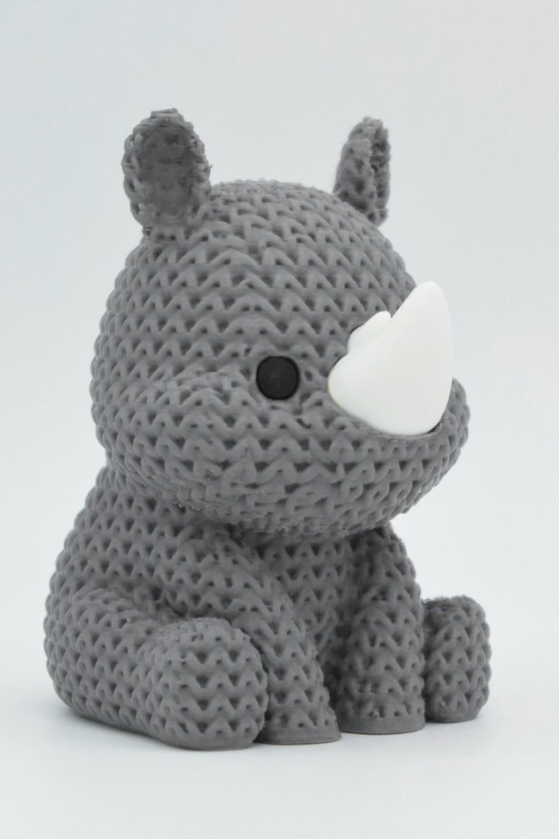Gros plan d'un rhinocéros tricoté, aspect crocheté et petites cornes, env. 80–100 mm