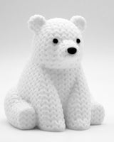 Gros plan d'une petite figurine d'ours polaire tricoté blanc, aspect crocheté, 8 cm de haut