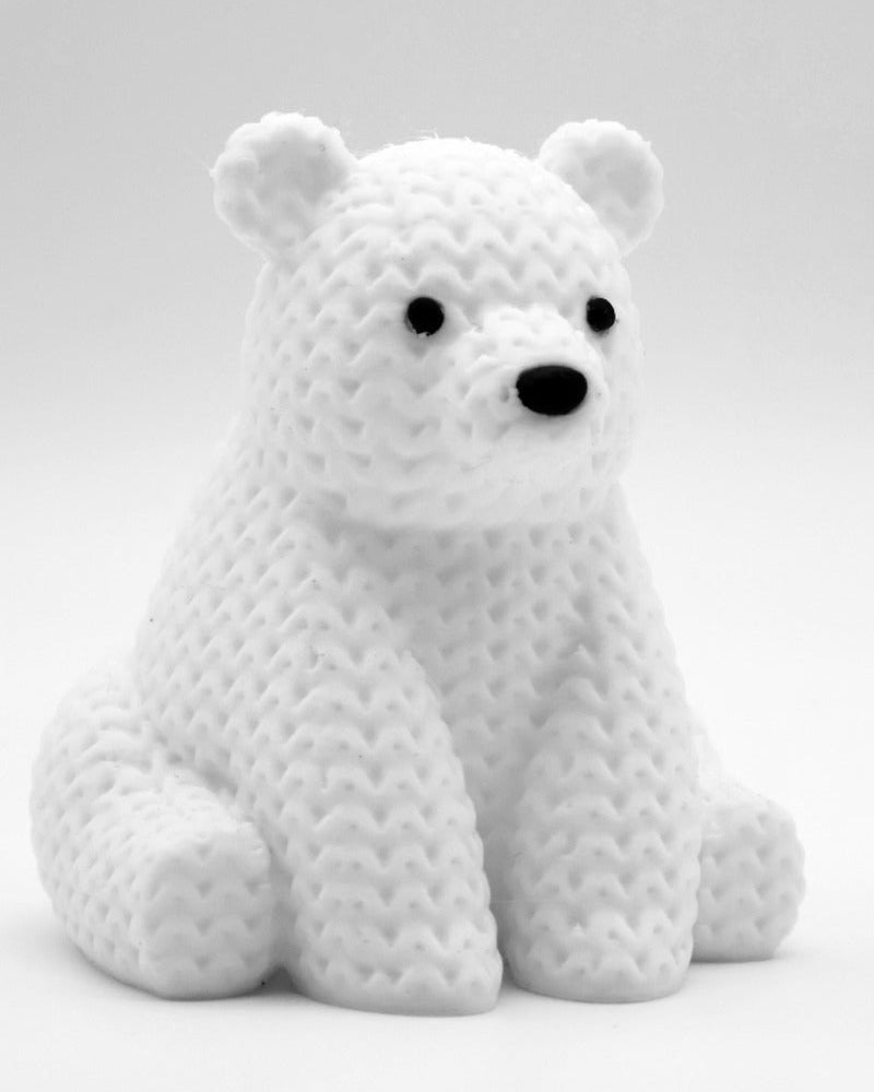Gros plan d'une petite figurine d'ours polaire tricoté blanc, aspect crocheté, 8 cm de haut