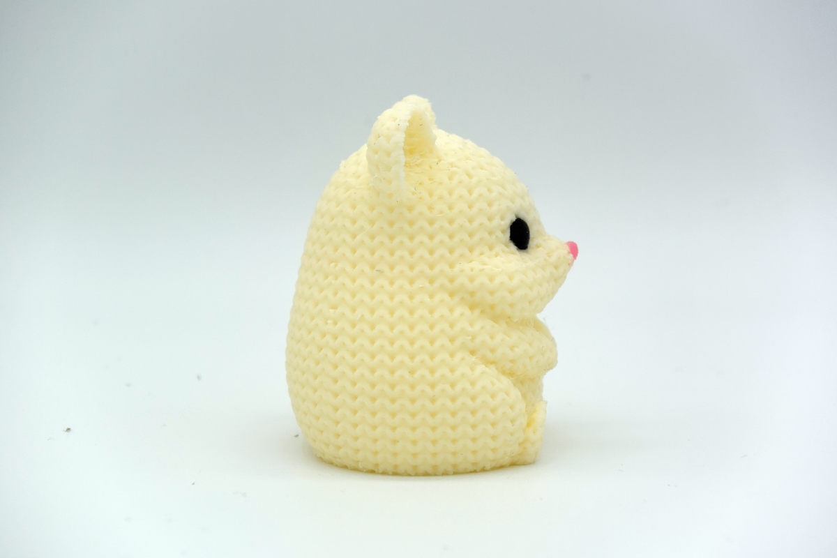 Gros plan d'un hamster tricoté, aspect crocheté, petits yeux ronds et nez