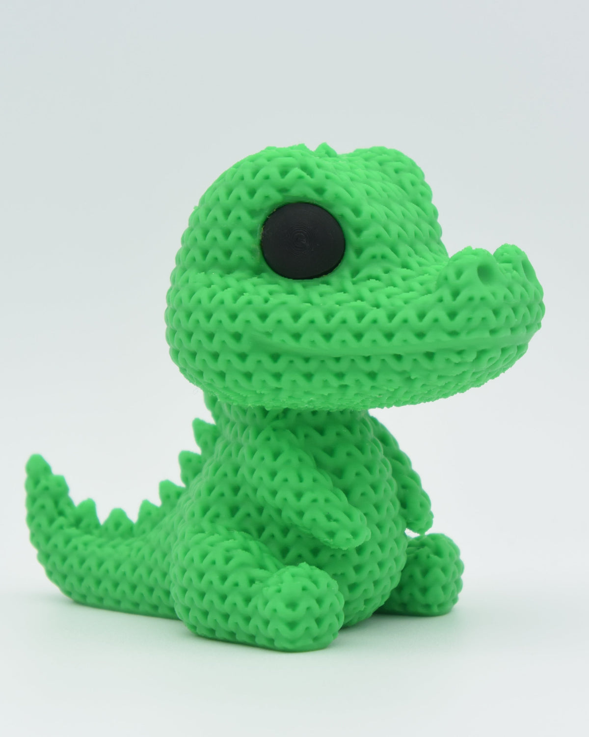 Gros plan d'un crocodile tricoté, aspect crocheté et petits yeux ronds, 80 mm de long