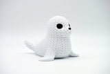 Gros plan d'une figurine décorative de phoque tricoté, aspect crocheté et petits yeux sombres