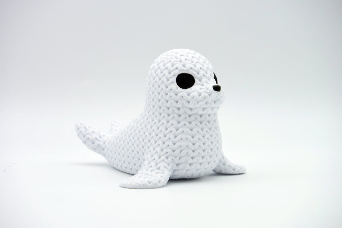 Gros plan d'une figurine décorative de phoque tricoté, aspect crocheté et petits yeux sombres