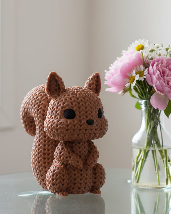 Gros plan d'une figurine d'écureuil tricoté, aspect crocheté et petits yeux de verre