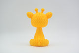 Gros plan d'une petite figurine de girafe tricotée à texture crochetée et yeux expressifs, env. 8 cm de haut