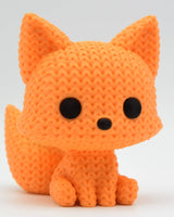 Gros plan d'une petite figurine de renard tricoté à mailles, yeux et nez posés à la main, 6 cm de haut
