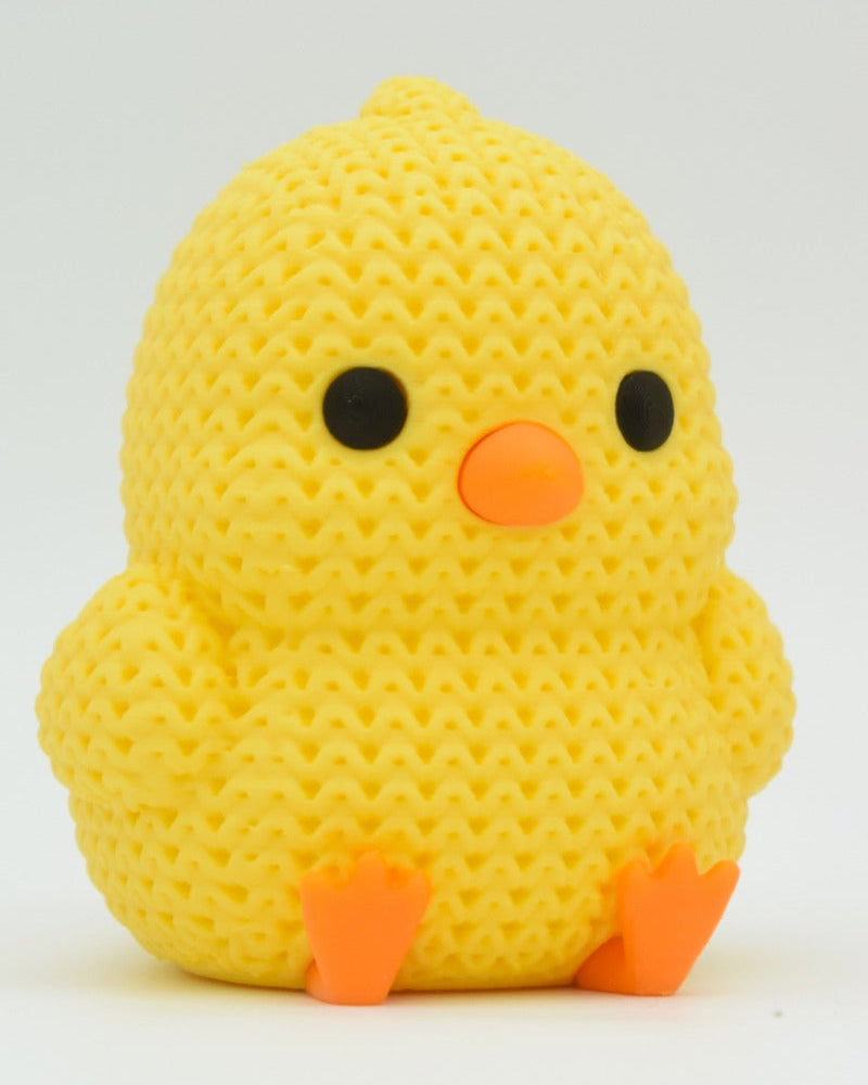 Gros plan d'un petit poussin tricoté jaune au bec et aux pattes orange