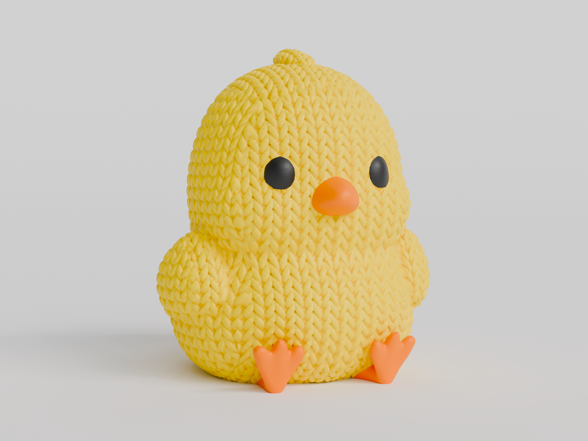 Gros plan d'un petit poussin tricoté jaune au bec et aux pattes orange