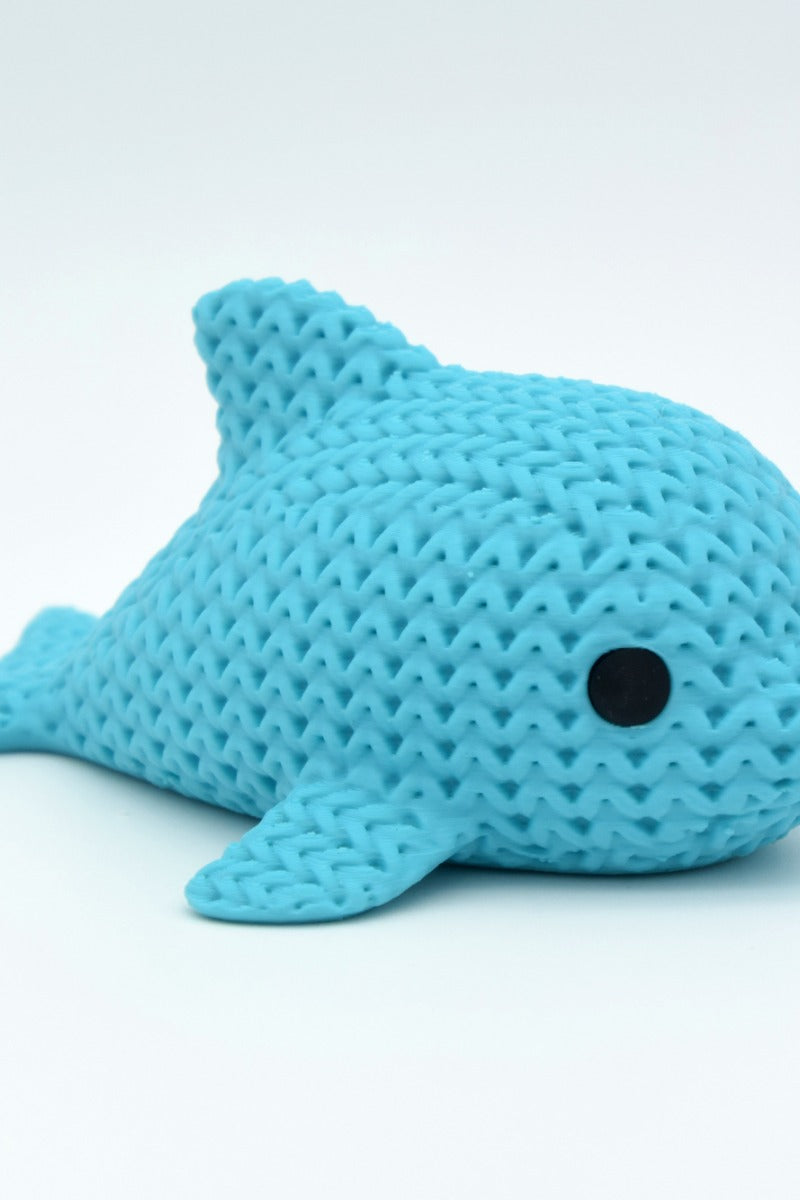 Gros plan d'une petite figurine de dauphin tricoté à texture crochetée et yeux ronds rapportés