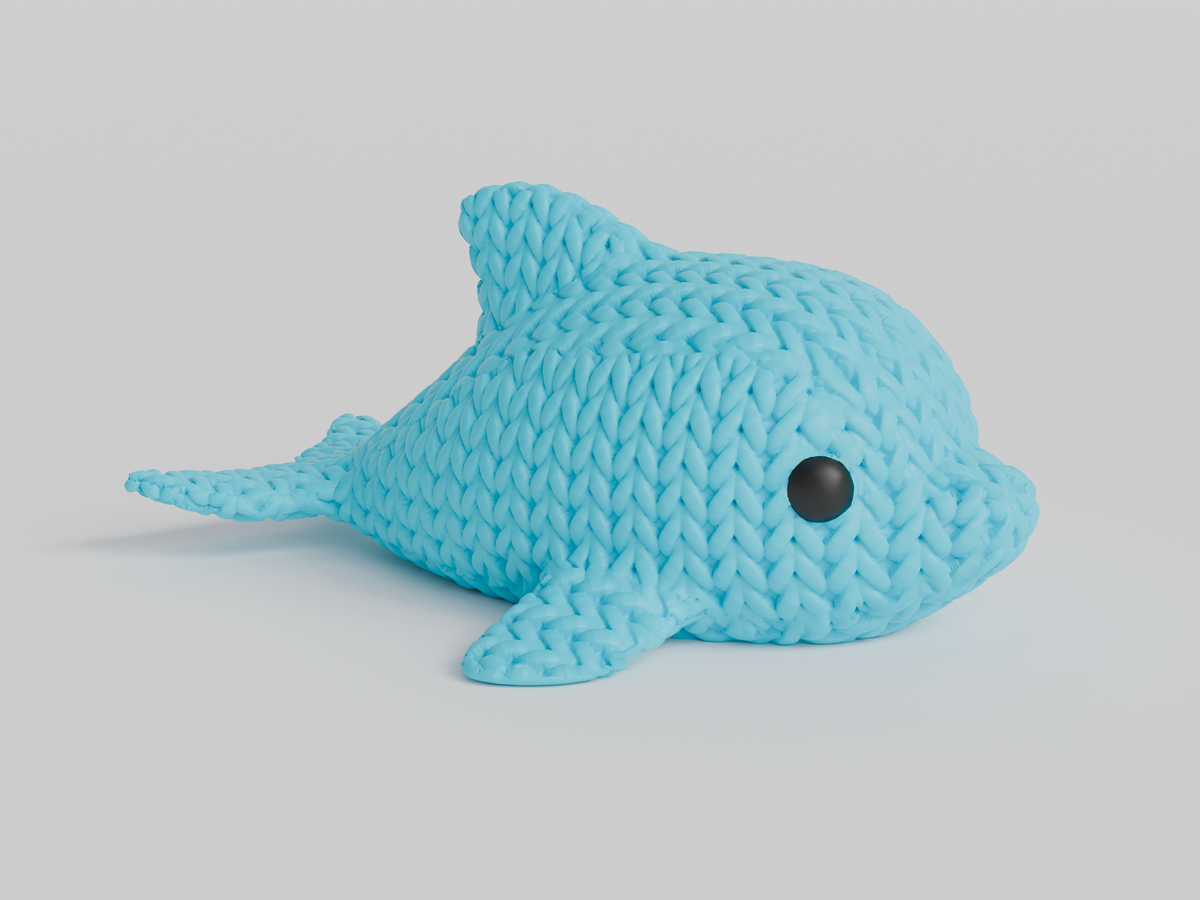 Gros plan d'une petite figurine de dauphin tricoté à texture crochetée et yeux ronds rapportés