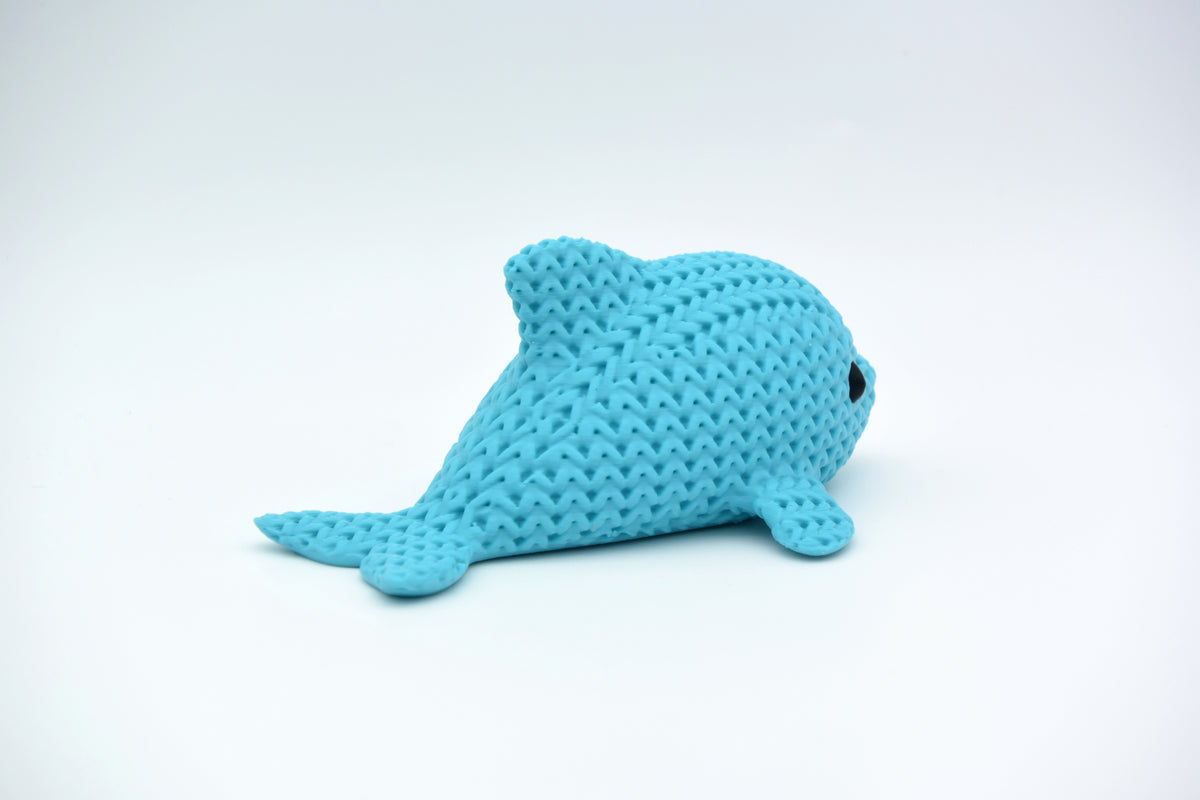 Gros plan d'une petite figurine de dauphin tricoté à texture crochetée et yeux ronds rapportés