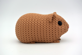 Macro de la structure à boucles façon crochet d'une figurine de cochon d'Inde aux tons neutres chauds