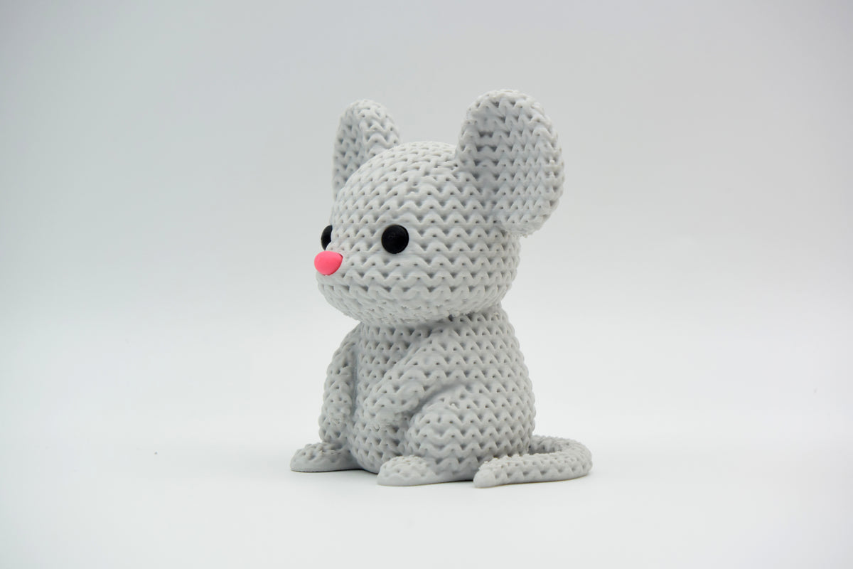 Petite souris façon tricot sur une étagère en bois près d'une plante en pot, intérieur scandinave
