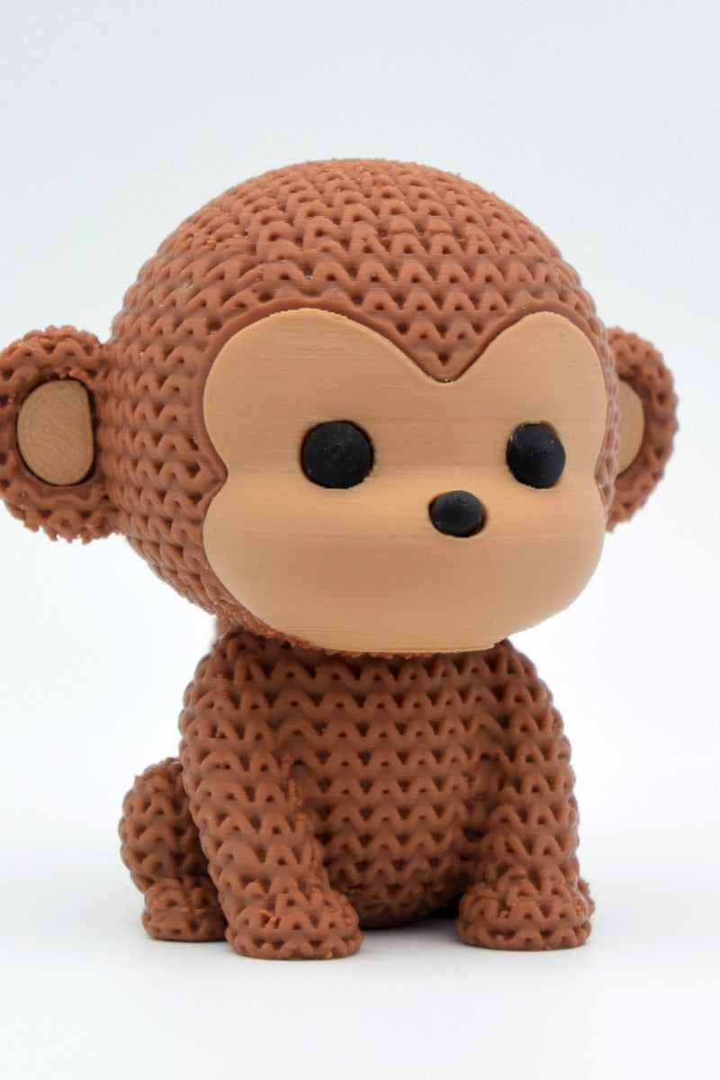 Gros plan d'une figurine de singe tricoté, aspect crocheté détaillé, sur surface claire