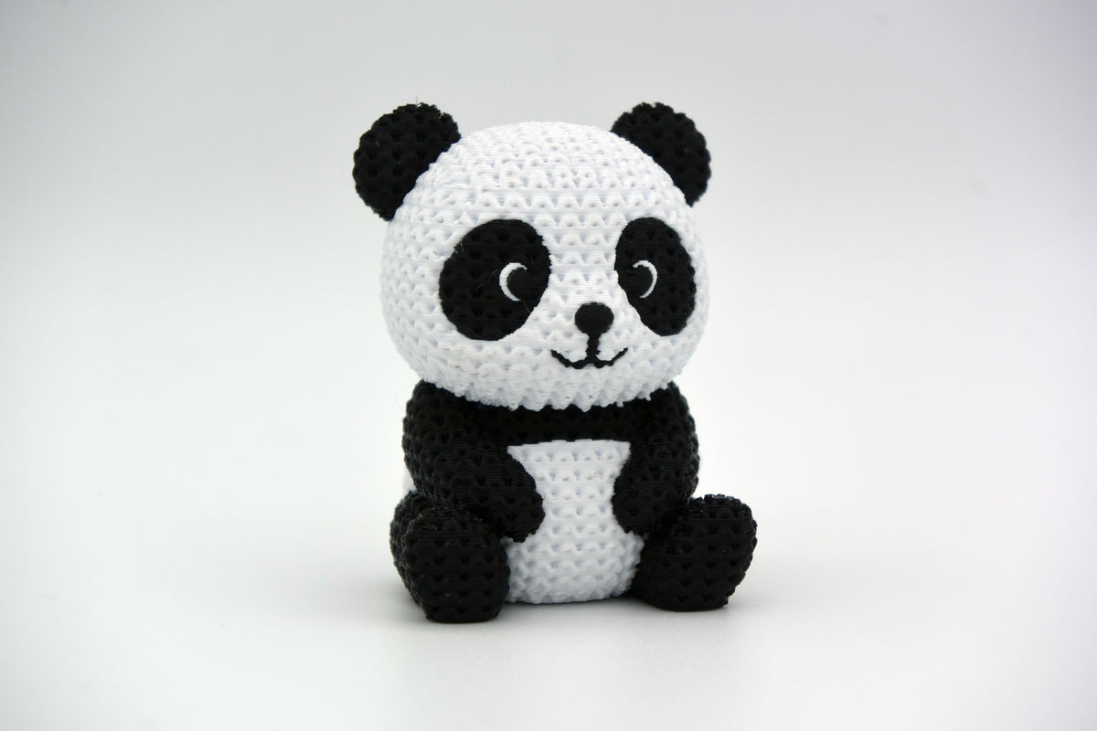 Figurine de panda tricotée sur une étagère en bois à côté de plantes et d'une déco neutre