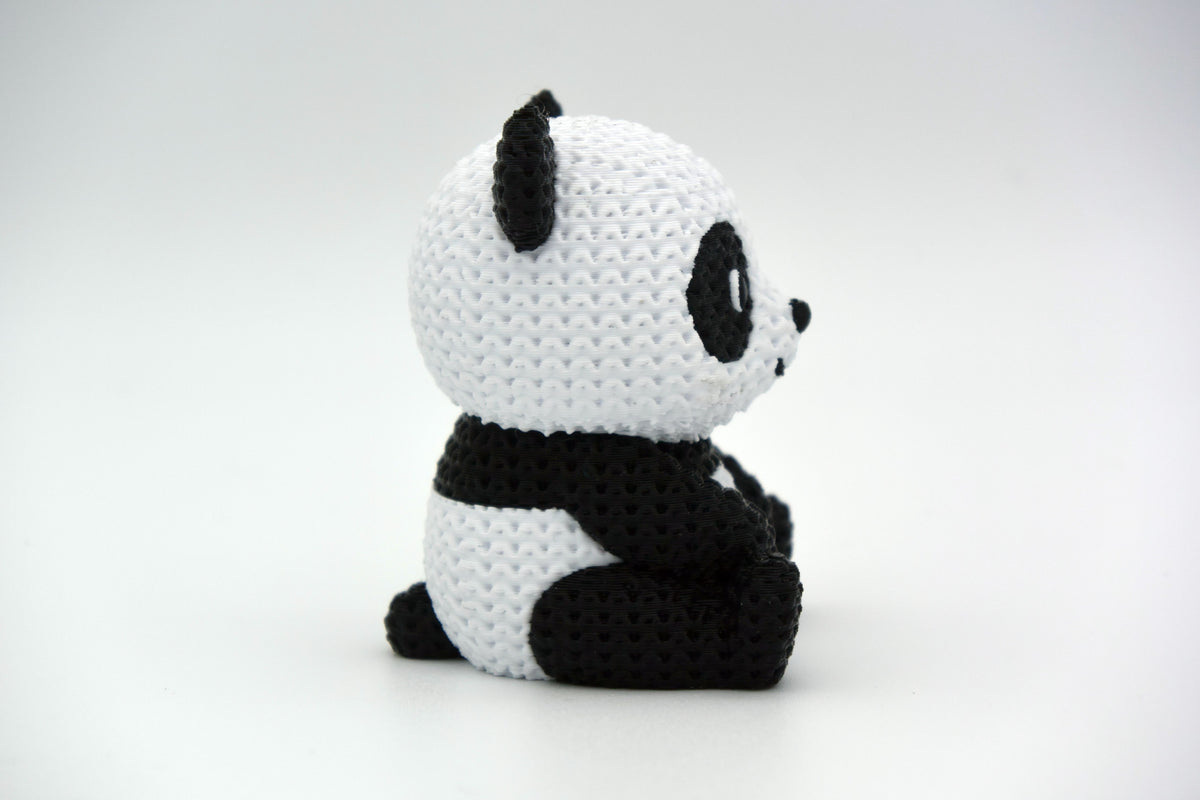 Gros plan des taches noires et blanches d'un panda tricoté