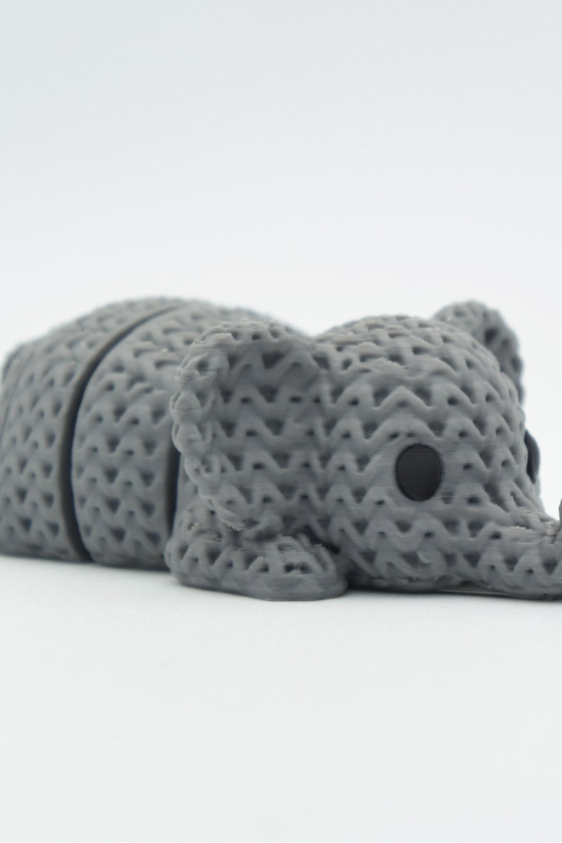 Gros plan d'un porte-clés éléphant tricoté à texture crochetée et corps articulé