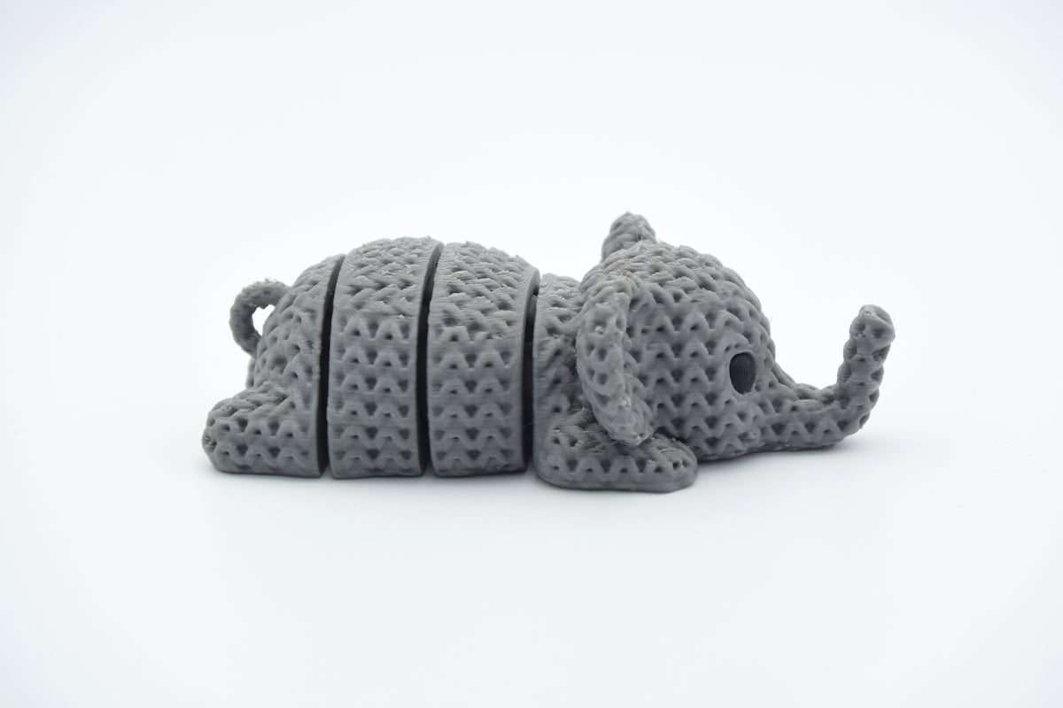 Petit porte-clés éléphant façon tricot sur un plan en bois avec clés de maison et pochette en lin