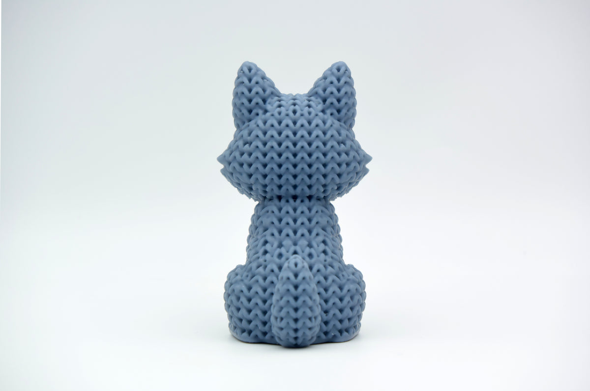 Gros plan d'une figurine de loup tricoté gris chaud à texture crochetée, env. 10 cm de haut
