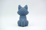 Gros plan d'une figurine de loup tricoté gris chaud à texture crochetée, env. 10 cm de haut