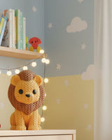 Gros plan d'une figurine de lion tricoté, aspect crocheté, sur fond clair