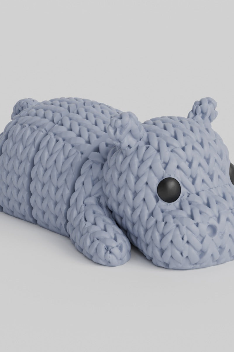 Gros plan d'une figurine d'hippopotame tricoté, aspect crocheté, sur fond blanc