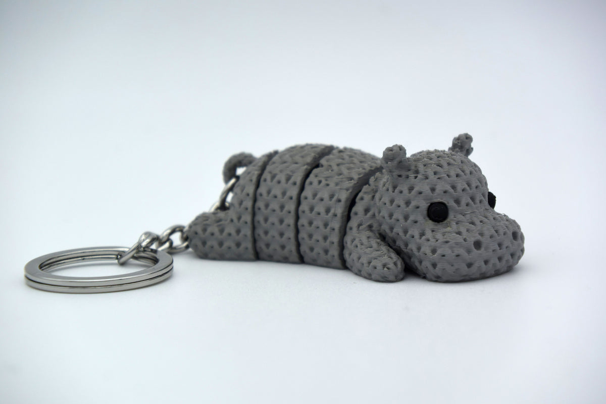 Petit hippopotame façon tricot sur un bureau en bois près d'une plante et d'une tasse de café