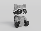 Gros plan d'une figurine de raton laveur tricoté, aspect crocheté détaillé, sur fond blanc
