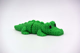 Gros plan d'un crocodile tricoté aux écailles crochetées et au corps articulé flexible