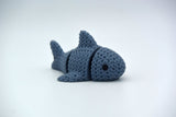 Gros plan d'un requin tricoté articulé à texture crochetée sur surface blanche
