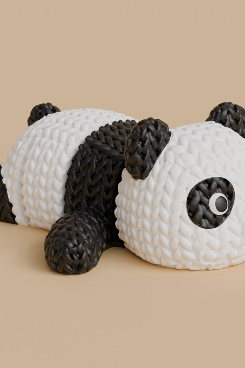 Figurine de panda tricoté articulé noir et blanc à l'aspect crocheté, gros plan